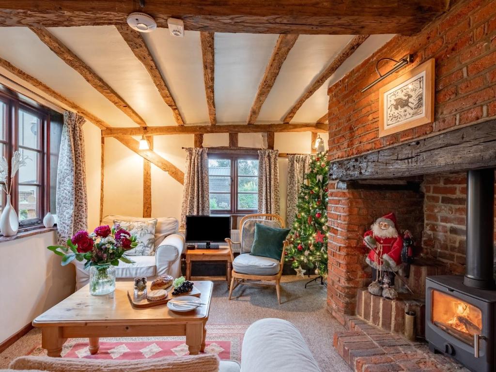 uma sala de estar com uma lareira de tijolos e uma árvore de Natal em 2 Bed in Tattingstone 86982 em Bentley
