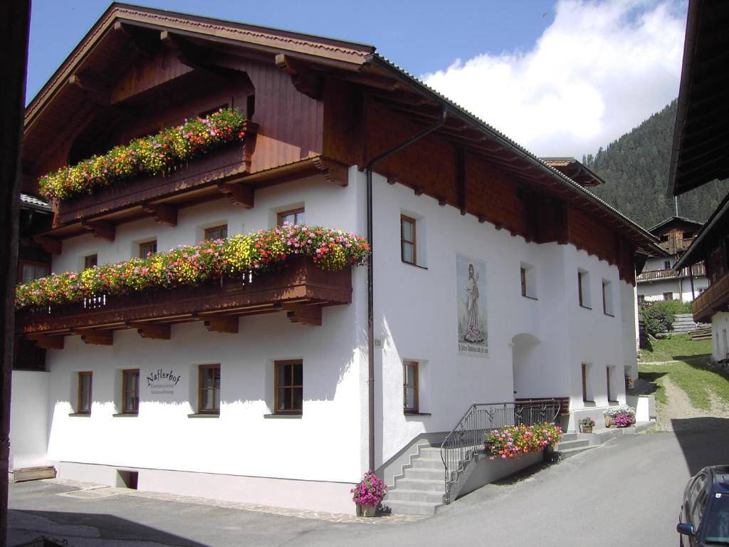 un edificio con cajas de flores en su lado en Naflerhof, en Obertilliach