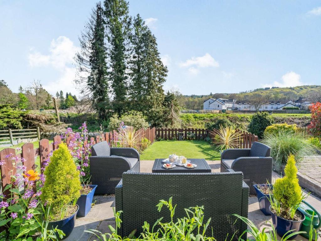 a patio with chairs and plants in a garden at 2 Bed in Newby Bridge 87621 in Newby Bridge
