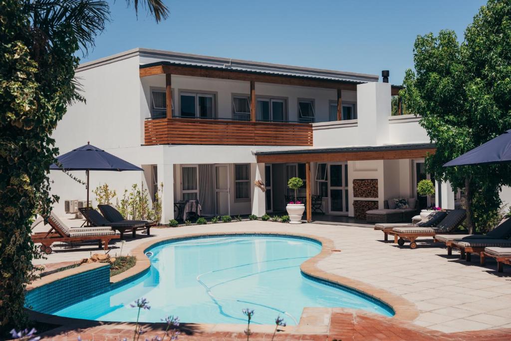 a swimming pool in front of a house at Mirabelle Guesthouse in Franschhoek