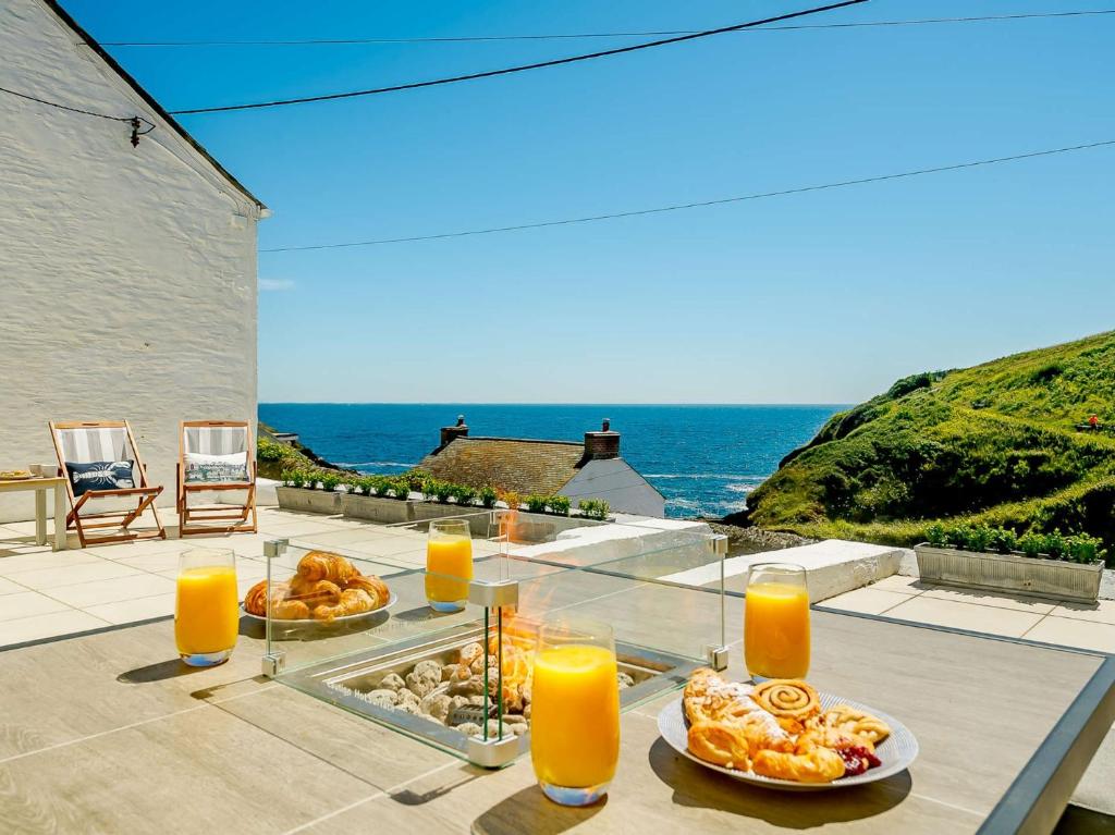 a table with two plates of food and orange juice at 3 Bed in Portloe 87260 in Portloe
