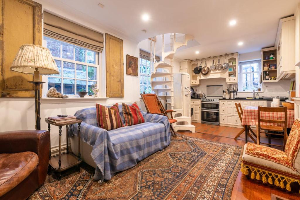 a living room with a couch and a kitchen at Character Cottage In Historic Hampstead in London