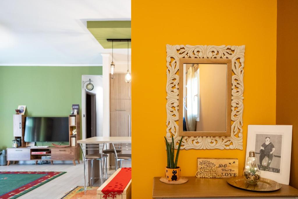 sala de estar con espejo en una pared amarilla en Art House, en Drama