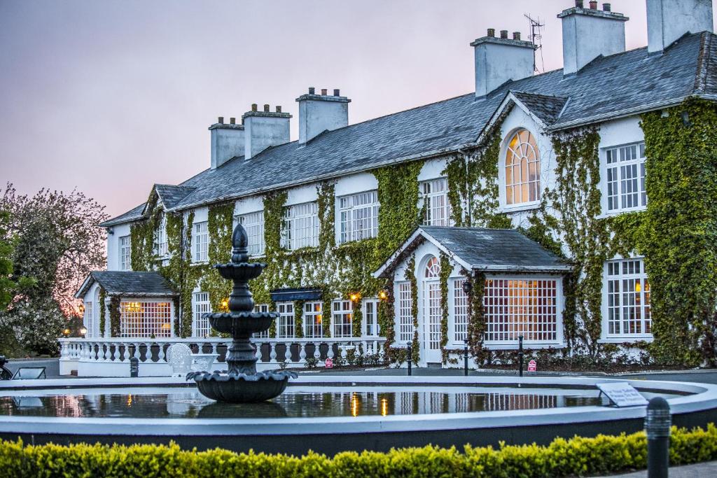 a large building with a fountain in front of it at Crover House Hotel & Golf Club in Mountnugent