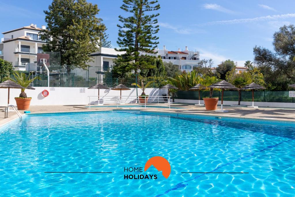 ein Swimmingpool in einem Hotel mit Gebäuden im Hintergrund in der Unterkunft #189 Montechoro Flat by Home Holidays in Vale de Pedras