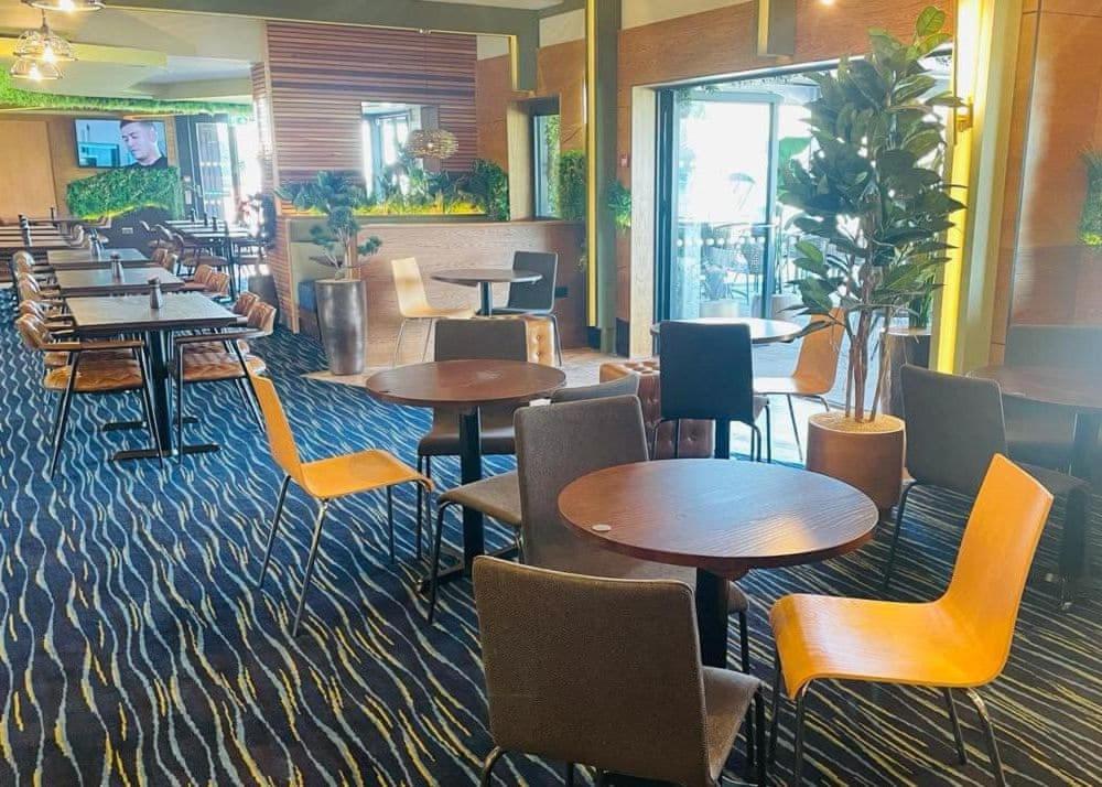 a restaurant with tables and chairs in a room at Appletree Holiday Park 