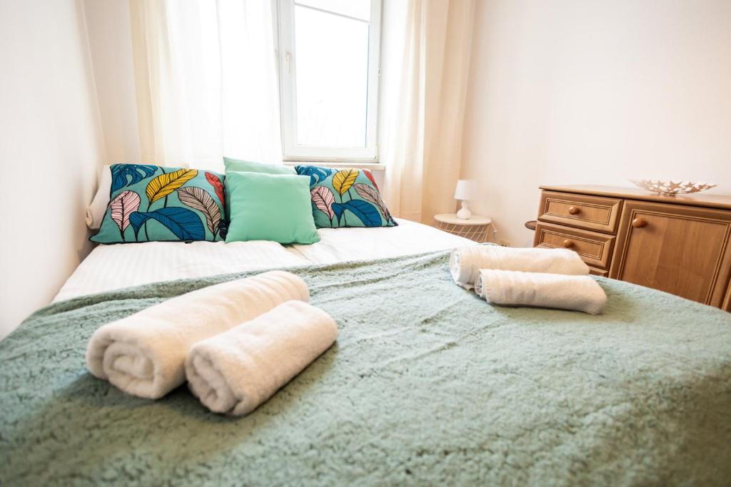 una camera da letto con due asciugamani su un grande letto di Marynia by Rentoom a Toruń