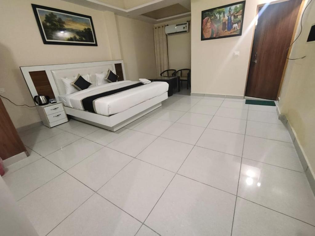 um quarto com uma cama e piso em azulejo branco em KHUSHI HOTEL & RESTAURANT em Haldwani
