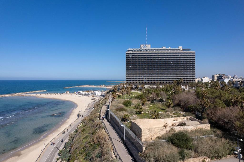 a view of the beach and a building at Hilton Tel Aviv Hotel in Tel Aviv
