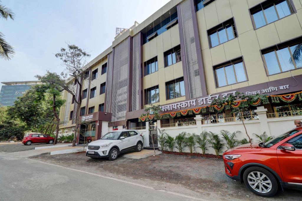 a red car parked in front of a building at Hotel Flysky Rooms & Banquets in Navi Mumbai