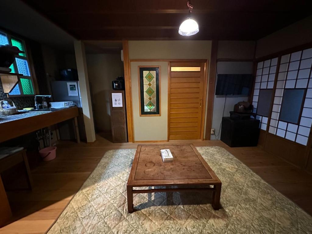ein Wohnzimmer mit einem Couchtisch vor einer Tür in der Unterkunft Marina and Numazu DX1F - Vacation STAY 64527v in Numazu