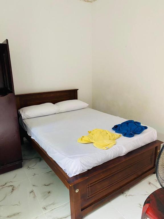 - un lit avec des draps blancs et des chemises jaunes dans l'établissement Enjoy Villa Weligama, à Weligama