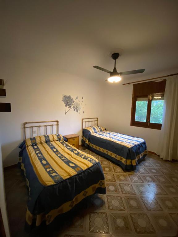 een slaapkamer met 2 bedden en een plafondventilator bij Villa 365 in La Rábita