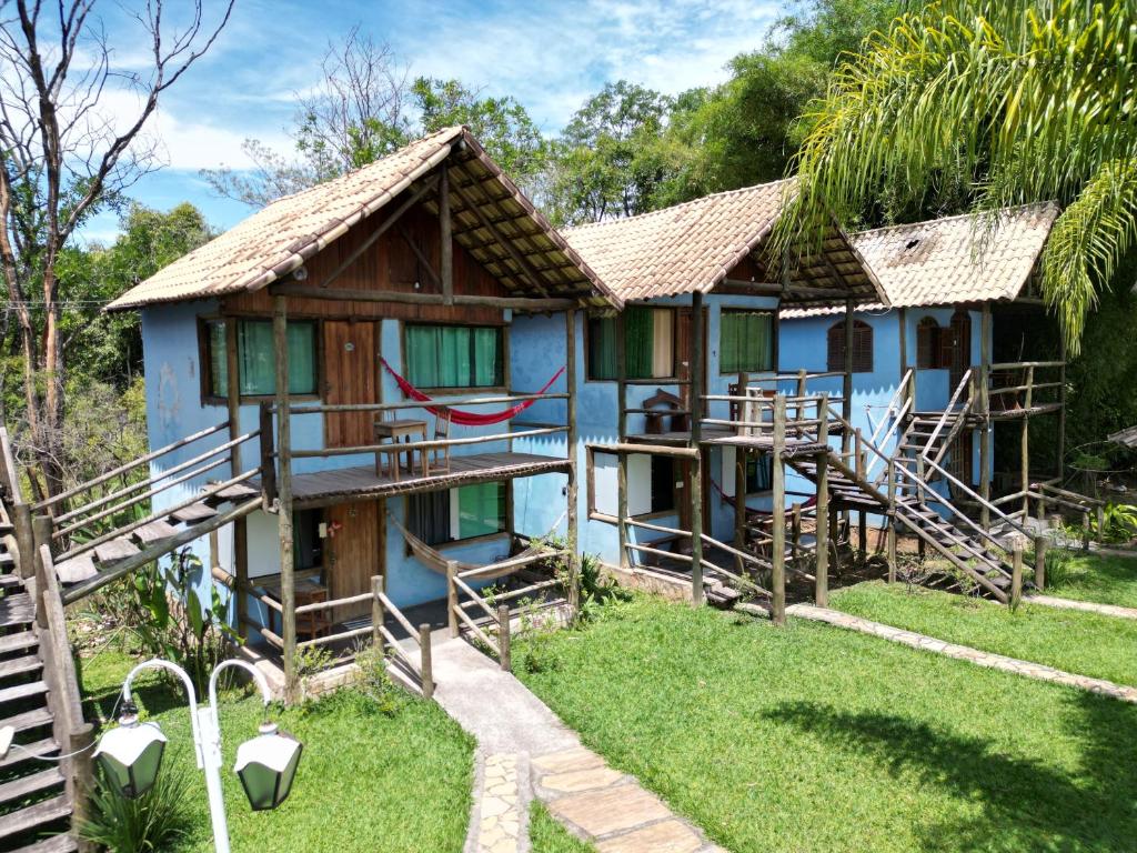 a blue house with green windows and a yard at Pousada Recanto dos Cisnes in Betim