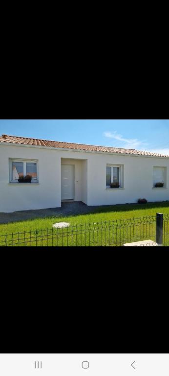 une maison blanche avec deux fenêtres et une clôture dans l'établissement Chambre Relax Détente, à Vairé