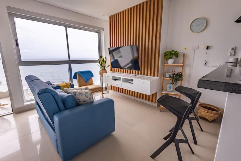 un salon avec un canapé bleu et une télévision dans l'établissement COMFORTABLE DEPARTAMENT IN FRONT THE SEA, à Carthagène des Indes