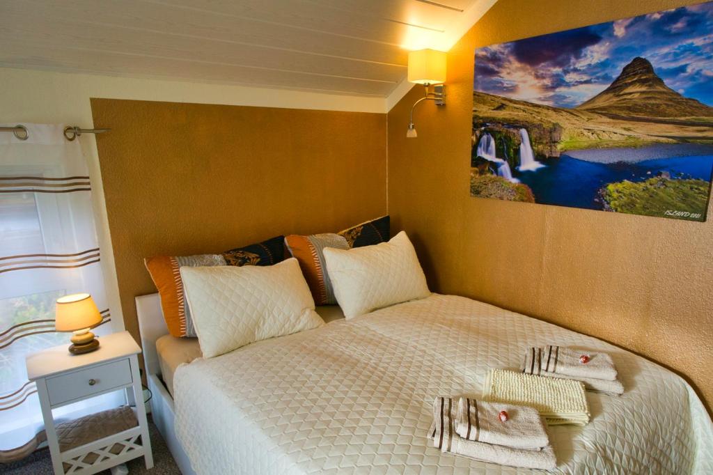 1 dormitorio con 1 cama y una pintura en la pared en My CozyPlace - Zimmer für Zwei en Dresden