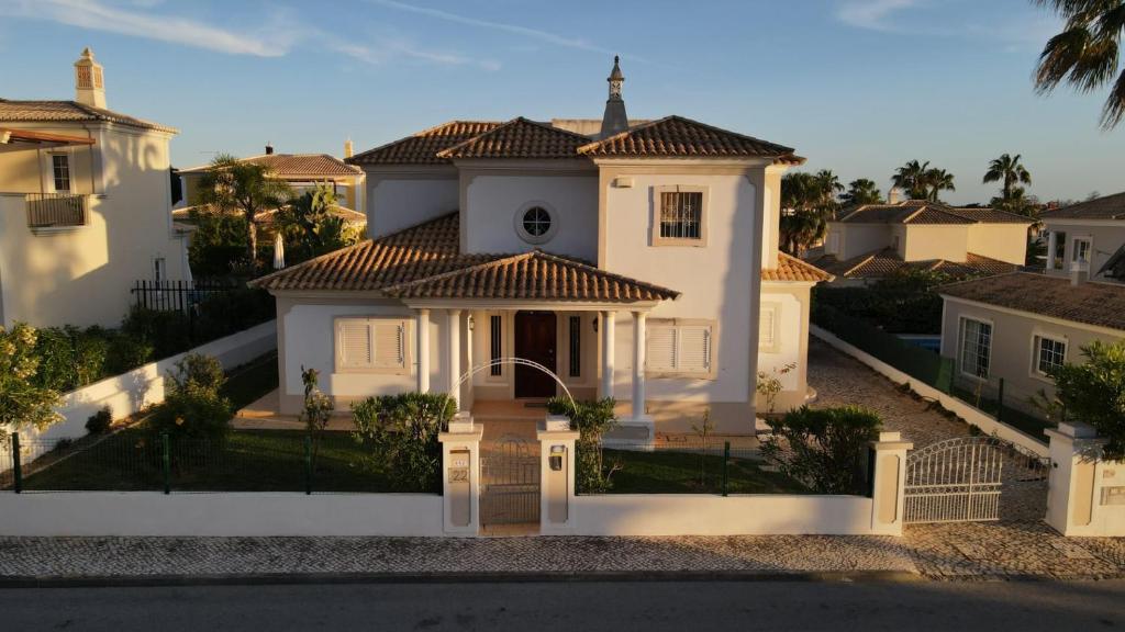 una casa blanca con una puerta y una valla en Santos Villa in Quinta do Lago, en Quinta do Lago