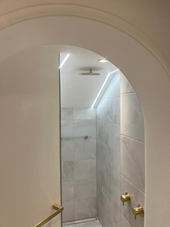 a shower with a glass door in a bathroom at Central London, South Kensington Apartment in London
