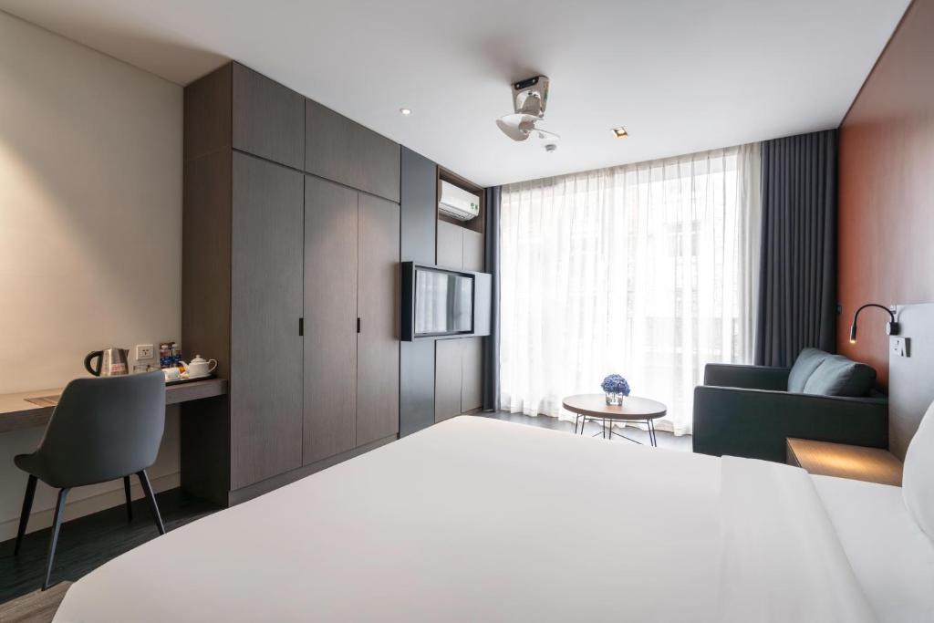 een hotelkamer met een groot bed en een bank bij Linn Hotel Bac Giang in Bắc Giang