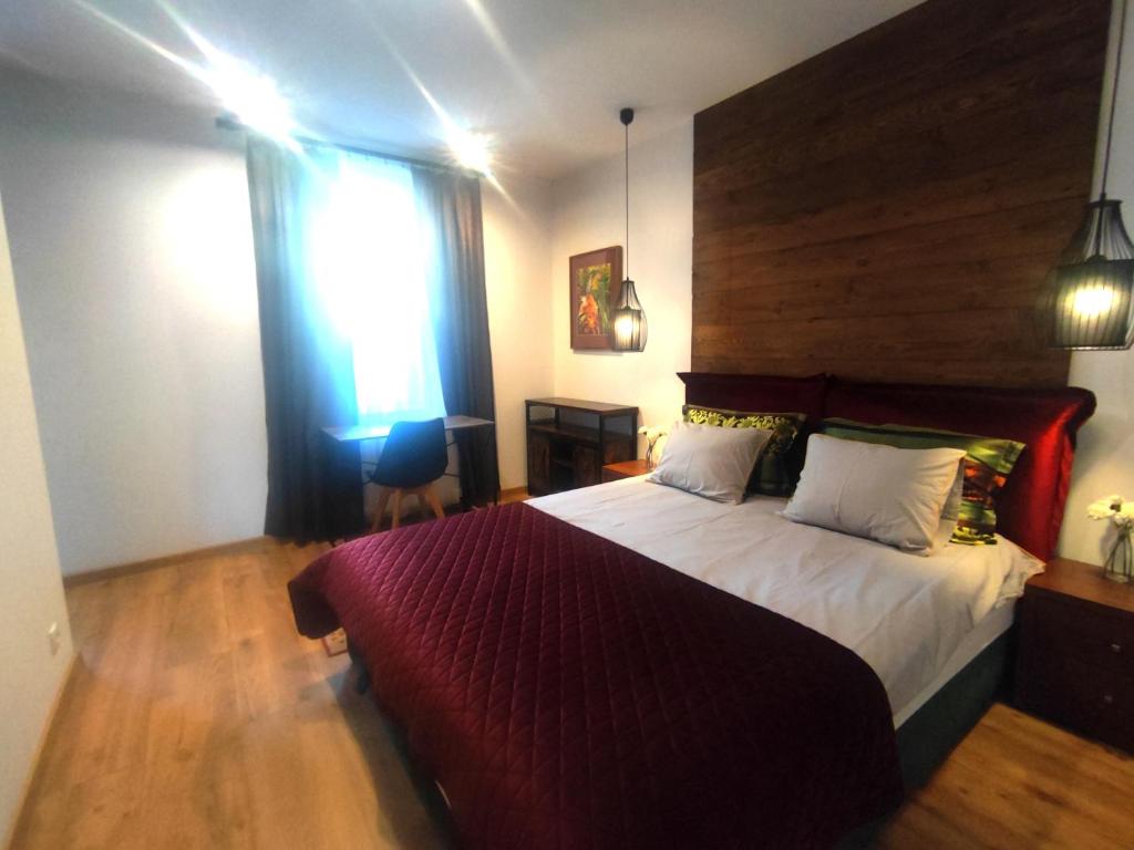 a bedroom with a large bed with a wooden headboard at Apartament Trawertynowy Chrobrego 15 Sopot in Sopot
