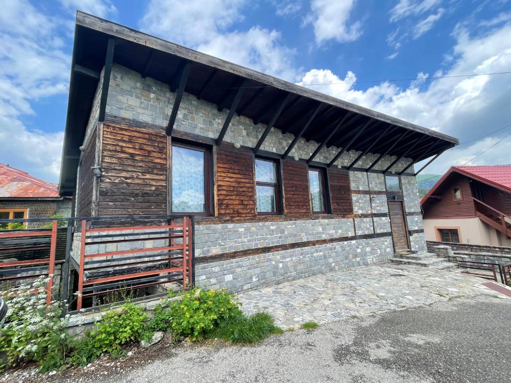 ブシュテニにあるCăsuța de piatrăの黒屋根のレンガ造り