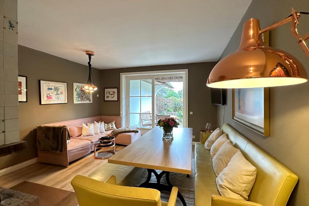 a living room with a table and a couch at Ameland Reethus in Wenningstedt in Wenningstedt