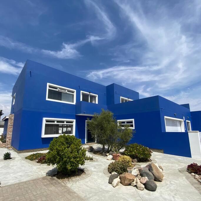 斯瓦科普蒙德的住宿－3 BDR Villa , unique in Swakopmund，前面有岩石的蓝色建筑