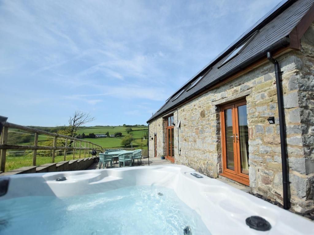 eine Badewanne vor einem Steinhaus in der Unterkunft 4 Bed in Kidwelly CWRTY in Kidwelly