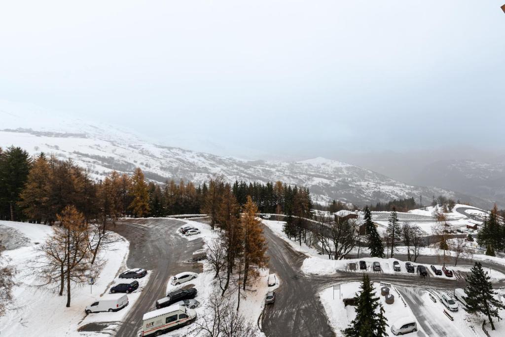 a group of cars parked in a parking lot in the snow at Bliss - Studio au pied des pistes in Villarembert