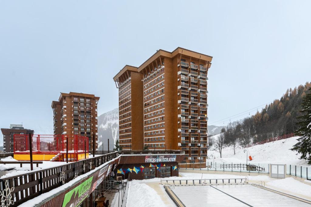 a large building in the snow next to some buildings at Bliss - Studio au pied des pistes in Villarembert
