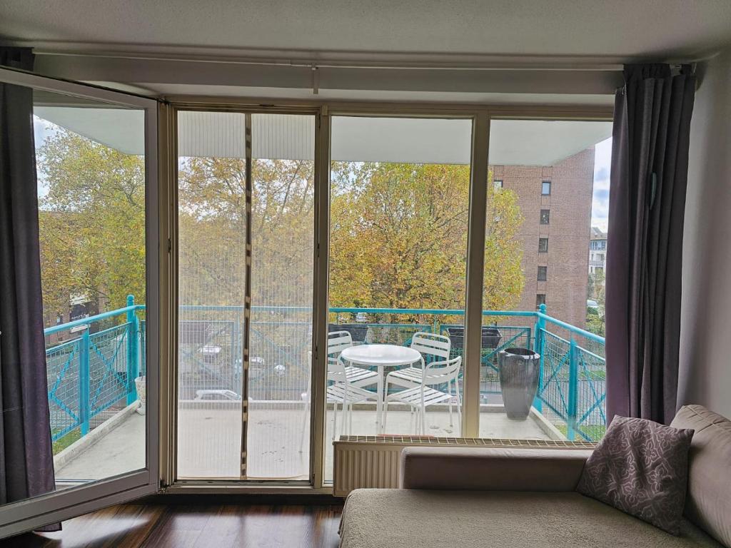 ein Wohnzimmer mit Glasschiebetüren und einem Balkon in der Unterkunft Übernachten Sie im wunderschönen Weiden in Köln