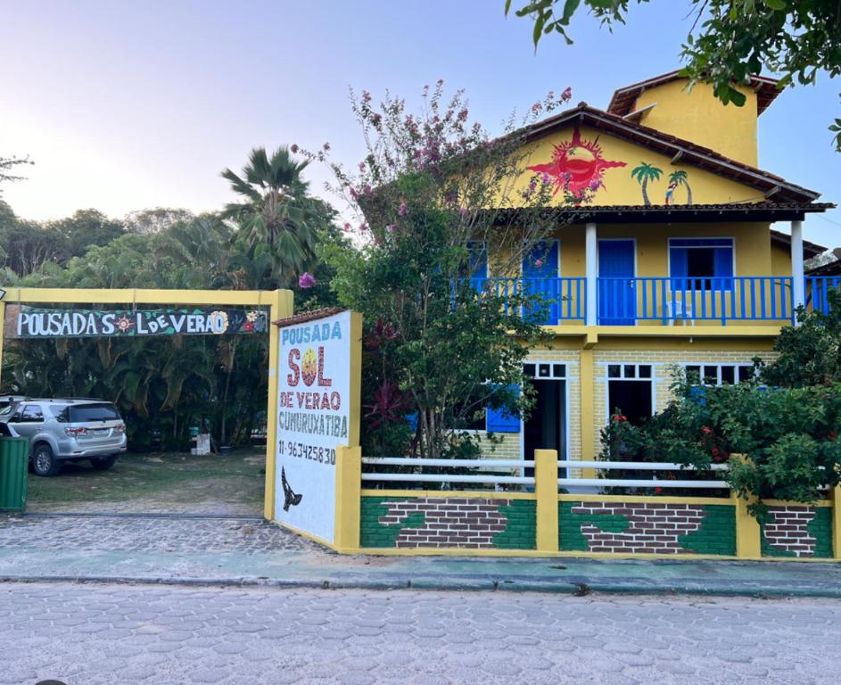 a yellow house with a sign in front of it at POUSADA SOL DE VERÃO - Cumuruxatiba -BA in Prado