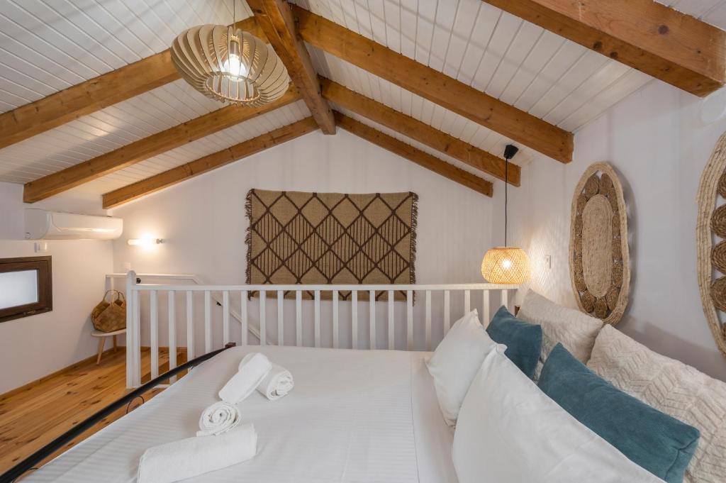 een wit bed in een kamer met houten plafonds bij Mariviky design apartment in Chania