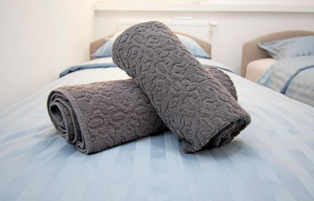 una pila de toallas sentadas encima de una cama en Apartmani Sebastijan, en Banja Luka