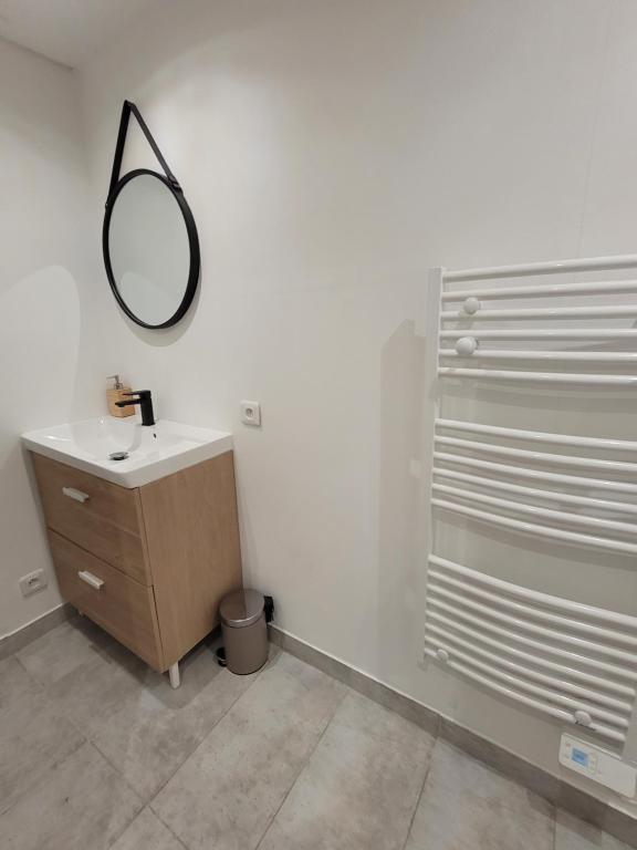 a bathroom with a sink and a mirror on the wall at Cosy Studio in Saint-Mitre-les-Remparts