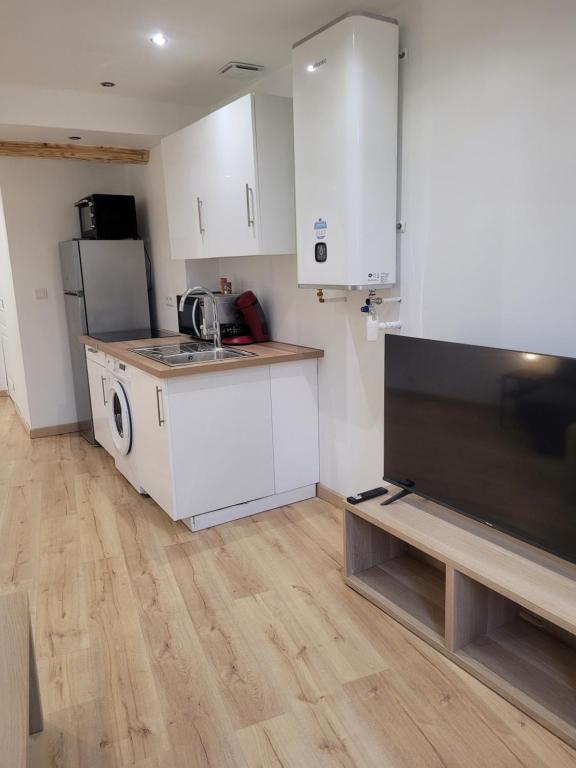 a small kitchen with a sink and a refrigerator at Cosy Studio in Saint-Mitre-les-Remparts