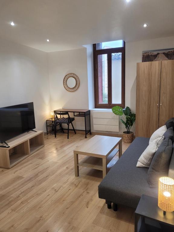 a living room with a couch and a table at Cosy Studio in Saint-Mitre-les-Remparts