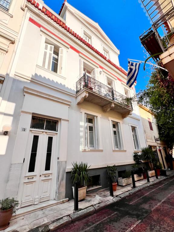 a white building with a balcony on a street at Athenian Getaway Villa in Plaka with Acropolis View by Athenian Homes in Athens