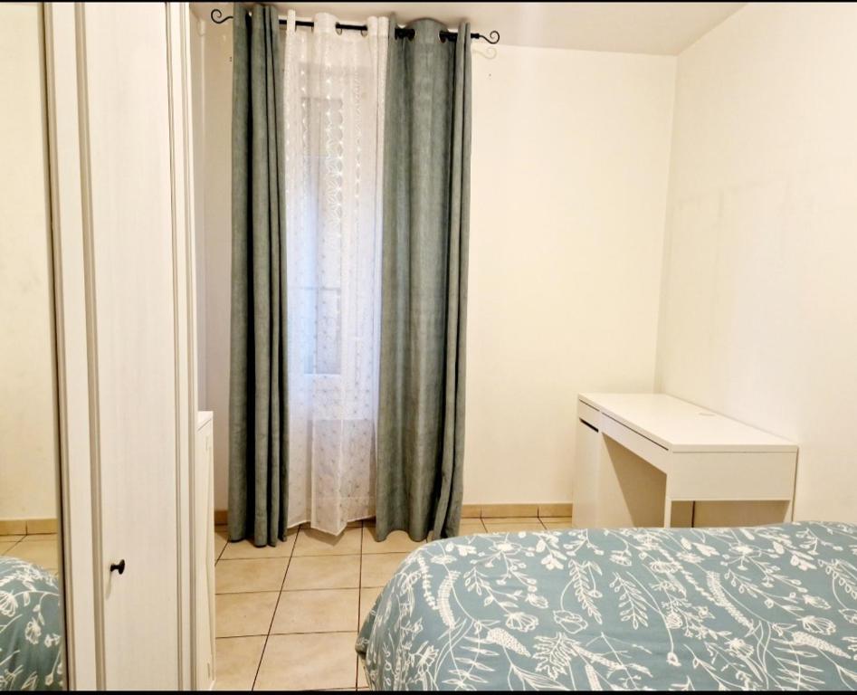 Schlafzimmer mit einem Bett, einem Schreibtisch und einem Fenster in der Unterkunft Charmant T2 Argenteuil in Argenteuil