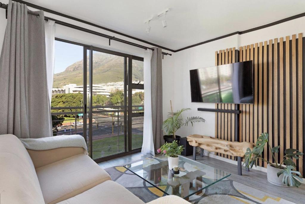 a living room with a couch and a table at Stunning Modern apartment Cape Town City Centre. in Cape Town