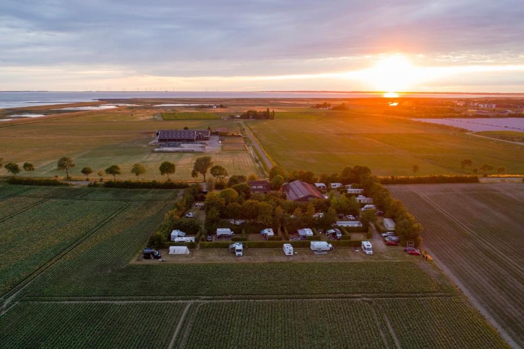 eine Luftansicht eines Bauernhofs mit Sonnenuntergang im Hintergrund in der Unterkunft Camping 'de Val' in Zierikzee