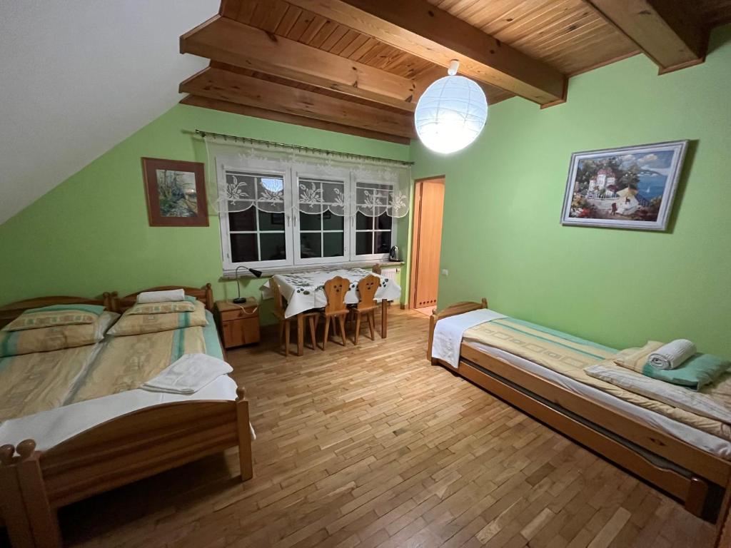a bedroom with two beds and a table in it at Pensjonat Malinówka in Szczyrk