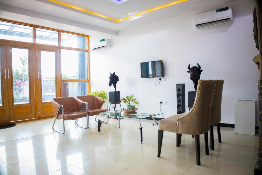 a living room with chairs and a glass table at Klulead Garden and Suites in Ijebu Ode