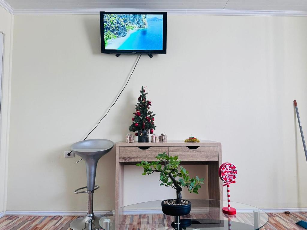 uma sala de estar com uma televisão na parede em Departamento amoblado calama em Calama