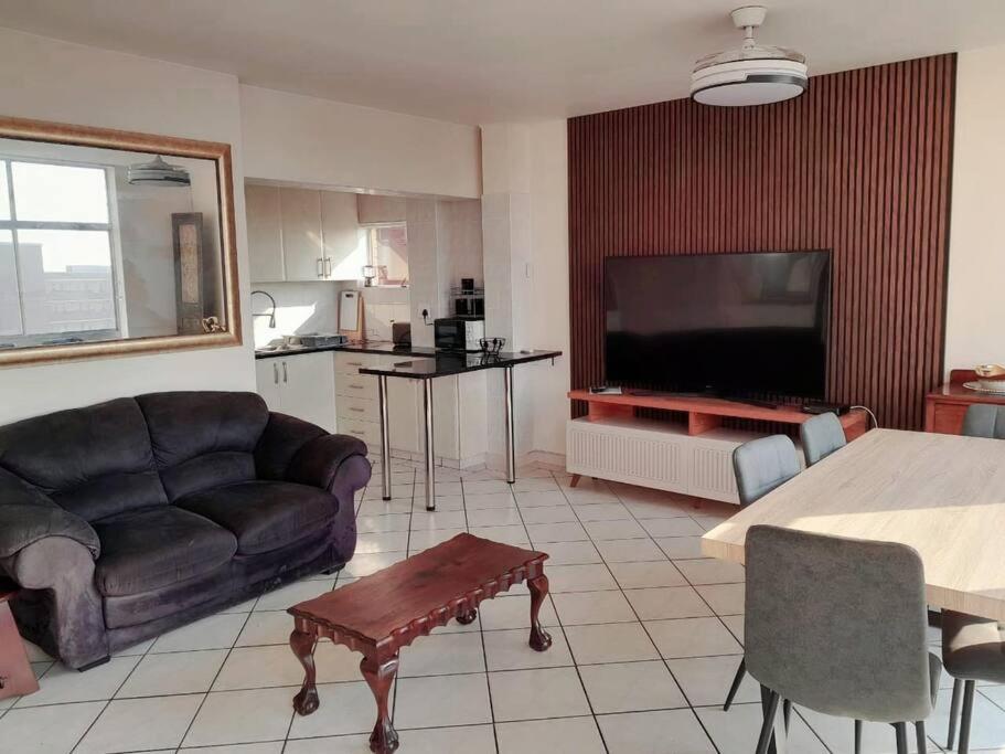 a living room with a couch and a large television at Cosy apartment by the sea in Durban