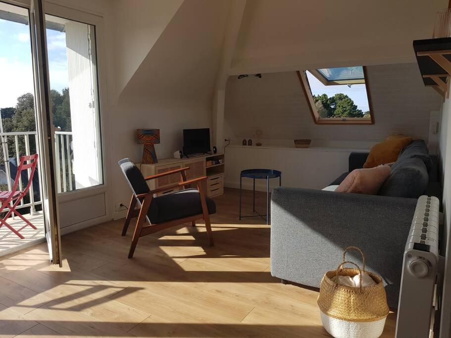 een woonkamer met een bank en een tafel bij Appartement cosy et rénové in Le Pouliguen