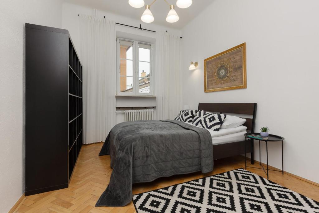 1 dormitorio con 1 cama y armario negro en One Bedroom Apartment Next to the Royal Castle in Warsaw by Renters, en Varsovia