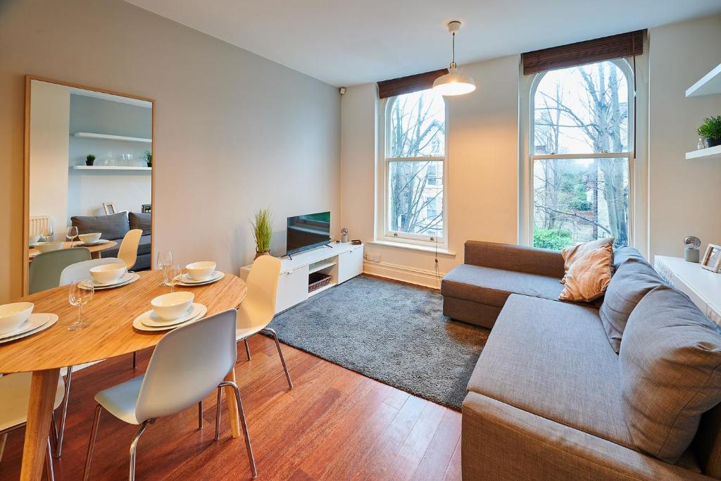 uma sala de estar com uma mesa e um sofá em Host & Stay - The Ivanhoe Retreat em Liverpool