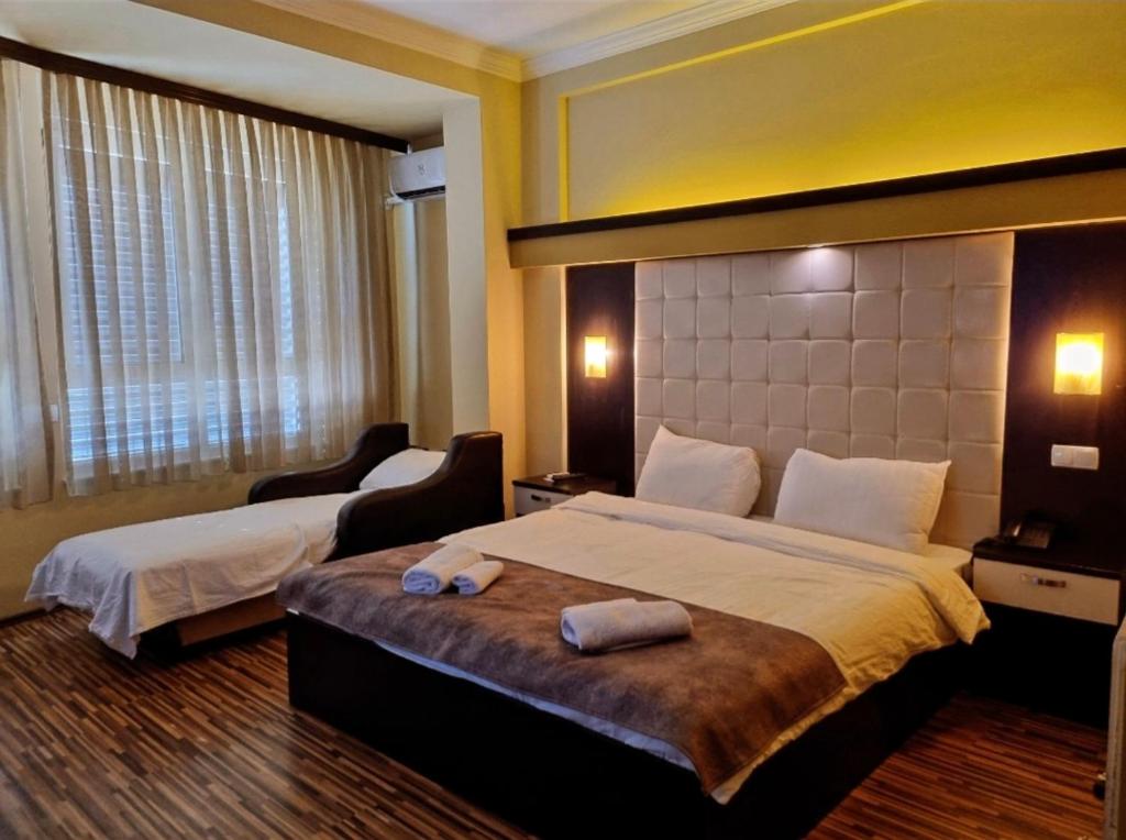 a hotel room with a large bed with towels on it at HOTEL ALBES in Prizren
